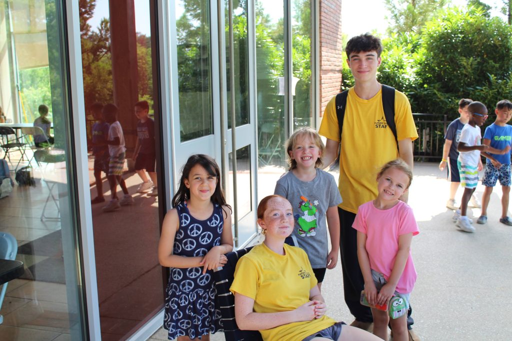 Two certified camp counselors with Traditional Day Camp campers outside